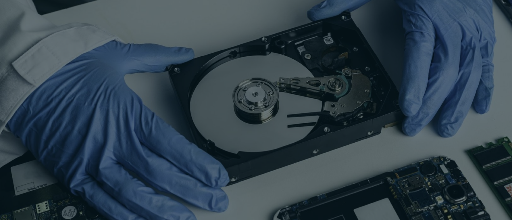 Engenheiro da RecoveryData manipulando um HD aberto em sala limpa Classe 100